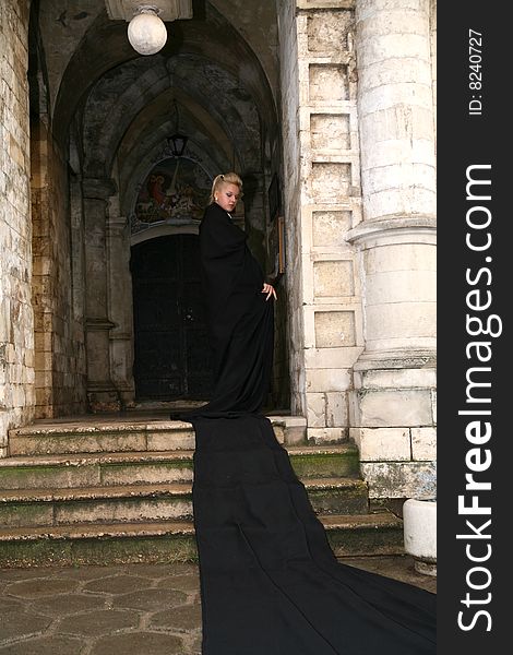 Lovely woman beside old castle in black fabric. Lovely woman beside old castle in black fabric