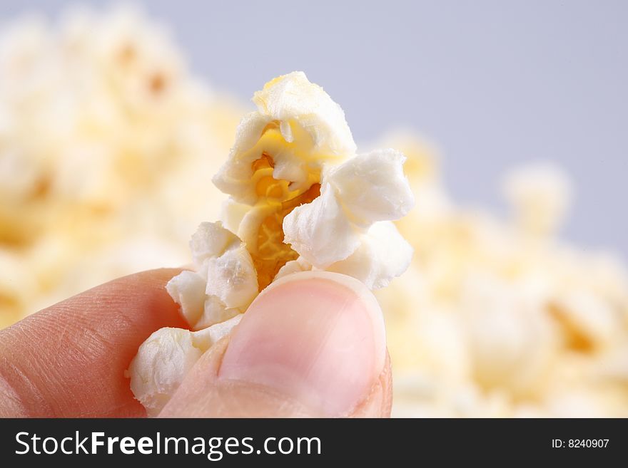 Closeup of a hand holding a popcorn