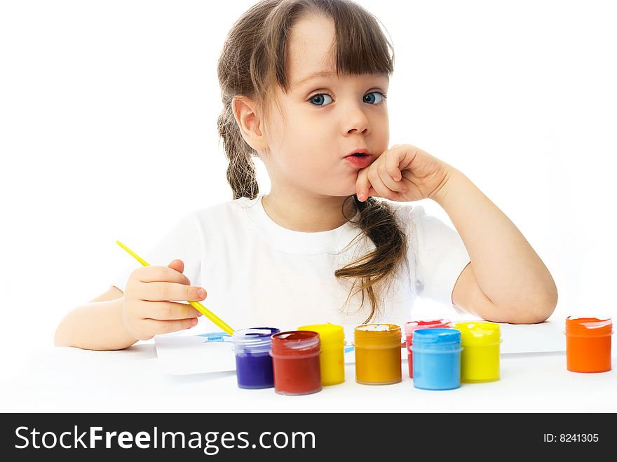 Cute little girl sitting by the table and painting with watercolor. Cute little girl sitting by the table and painting with watercolor