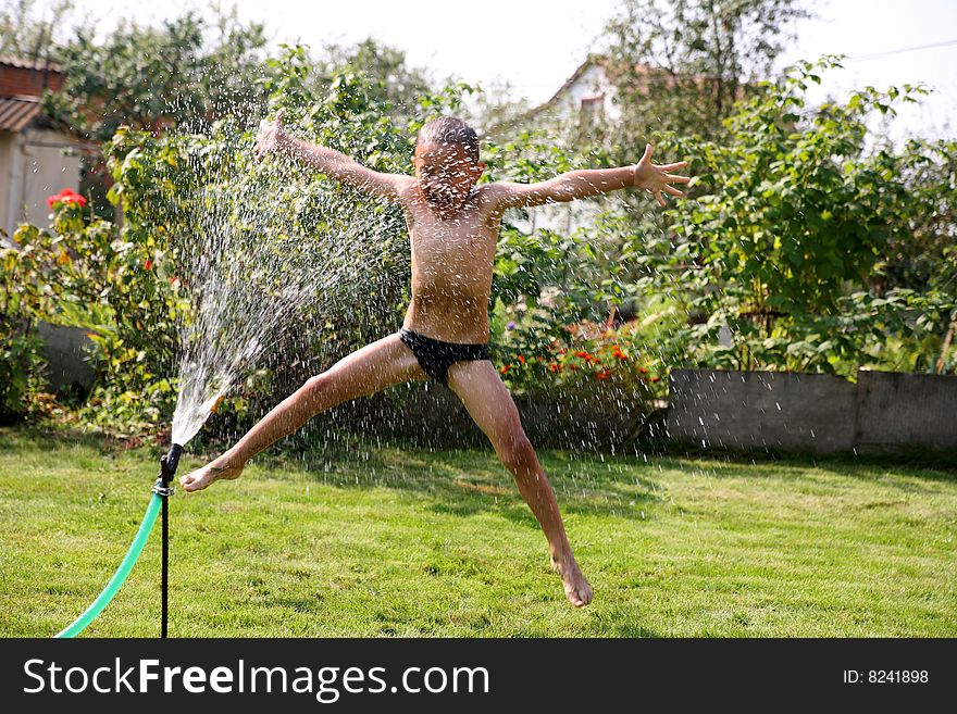 Jumping boy under summer shower