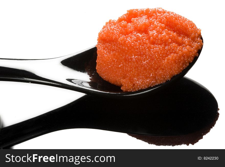 Red russian caviar in a black spoon
