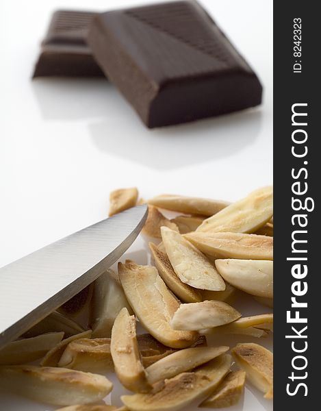 Pile of split roasted almonds and dark chocolate pieces on white background. Pile of split roasted almonds and dark chocolate pieces on white background.