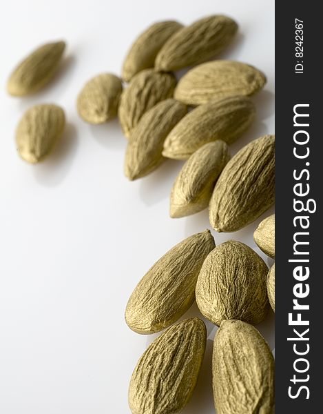 Pile of golden almonds on white background