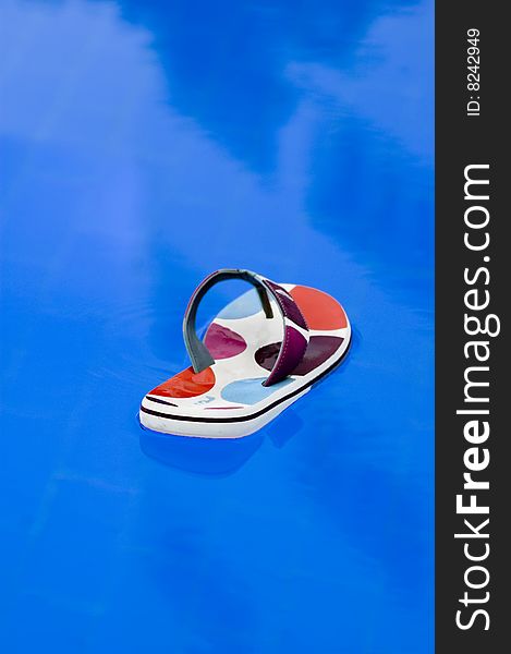 Colorful beach shoe floating around in a pool