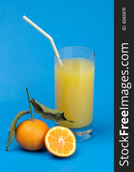 Tangerines and juice on a dark blue background. Tangerines and juice on a dark blue background