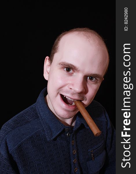 Young man with cigar on black background