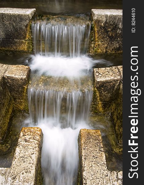 A stone waterfall with golden tones.