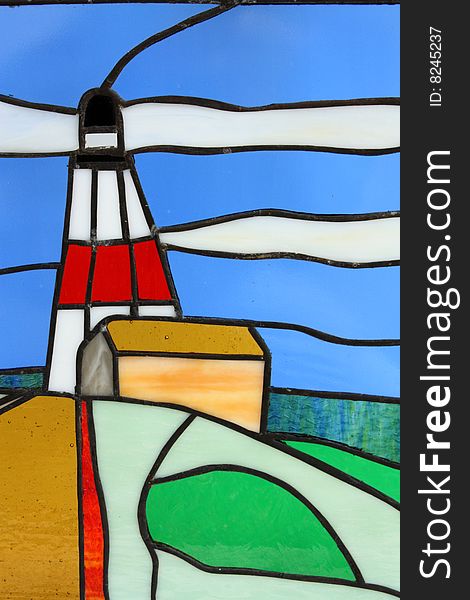 Stainglass lighthouse with clouds and blue sky.