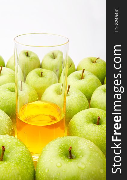 Apple juice in a glass among apples