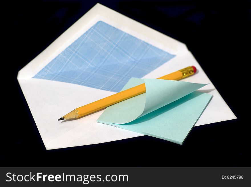 Pencil and note against the black background. Pencil and note against the black background