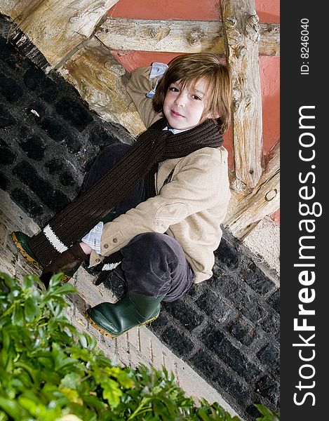 Cute young autumn boy standing near cottage. Cute young autumn boy standing near cottage