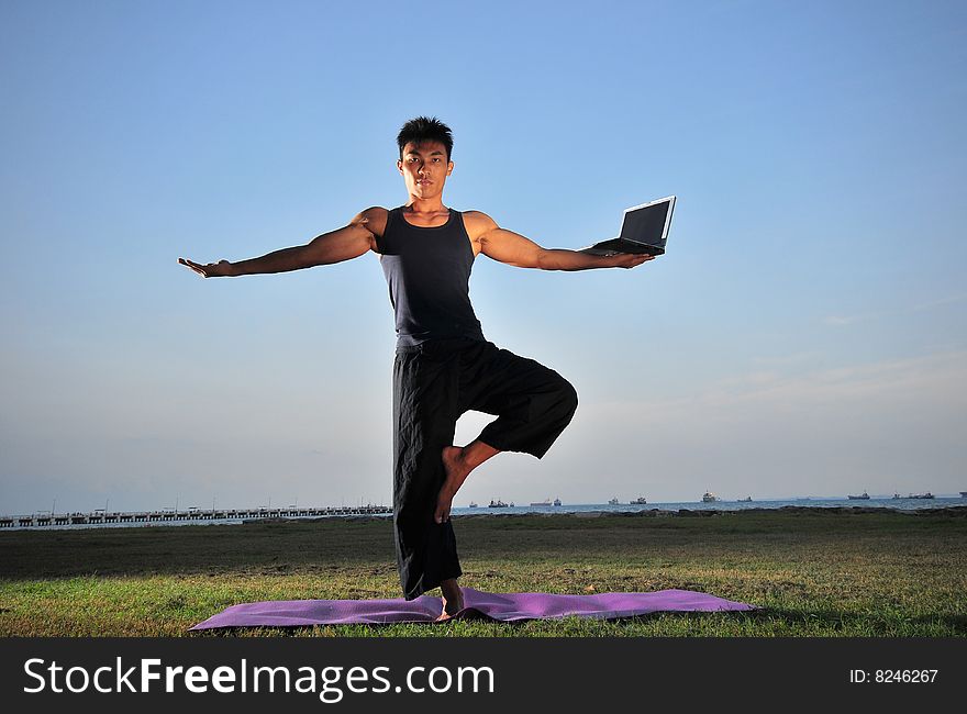 Picture of man doing yoga by the beach.