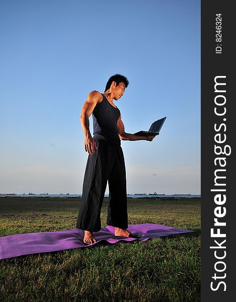 Picture of man doing yoga by the beach.