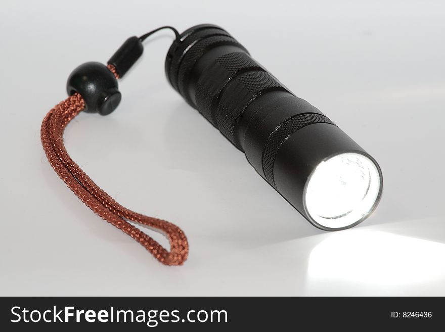 A black High Intensive Discharge(HID) flashlight working. A black High Intensive Discharge(HID) flashlight working