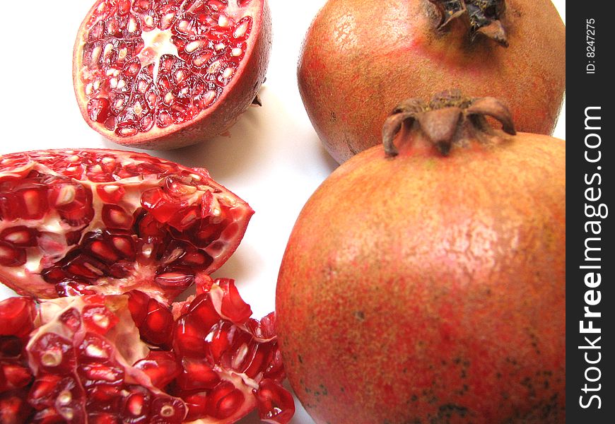 Full Pomegranates and Cut ones on white Background