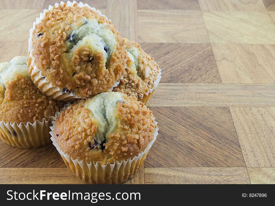 Several blueberry muffins on a wooden texture