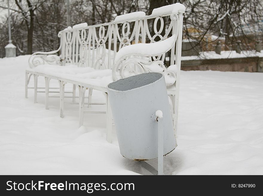 Urn for dust against a white snow-covered bench