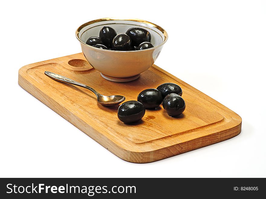 Olive in white cup on wooden plate