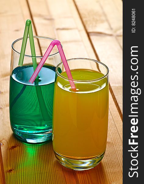 Cocktail and juice on wooden table