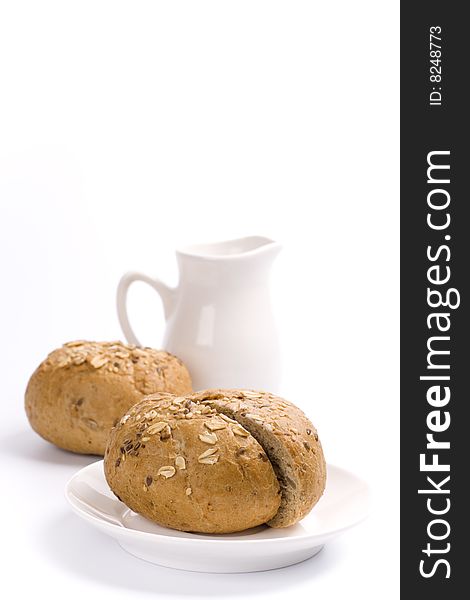 Bread and jug of milk on white background