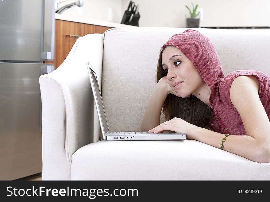 A young woman using a laptop in a modern home. A young woman using a laptop in a modern home.