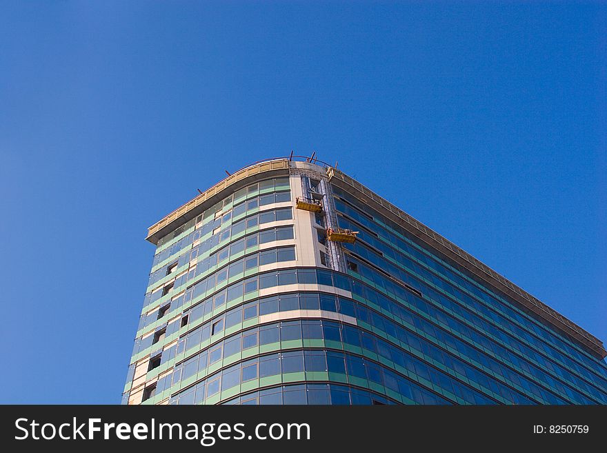 Finishing works on building construction on blue sky