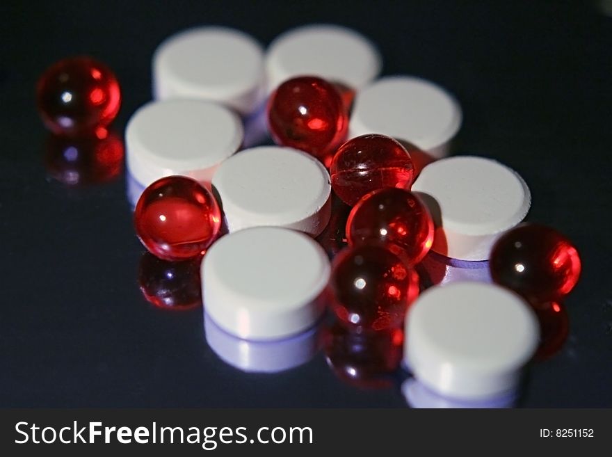 Vitamines in red and white tablets in close up. Vitamines in red and white tablets in close up