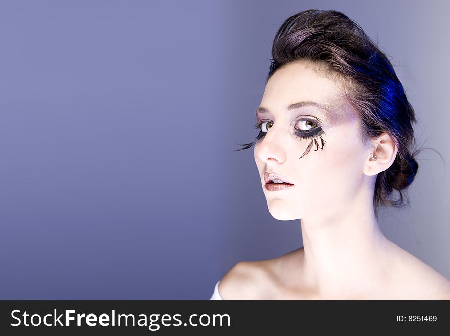 Attractive young lady with extravegant makeup and eyelashes head tilted to side