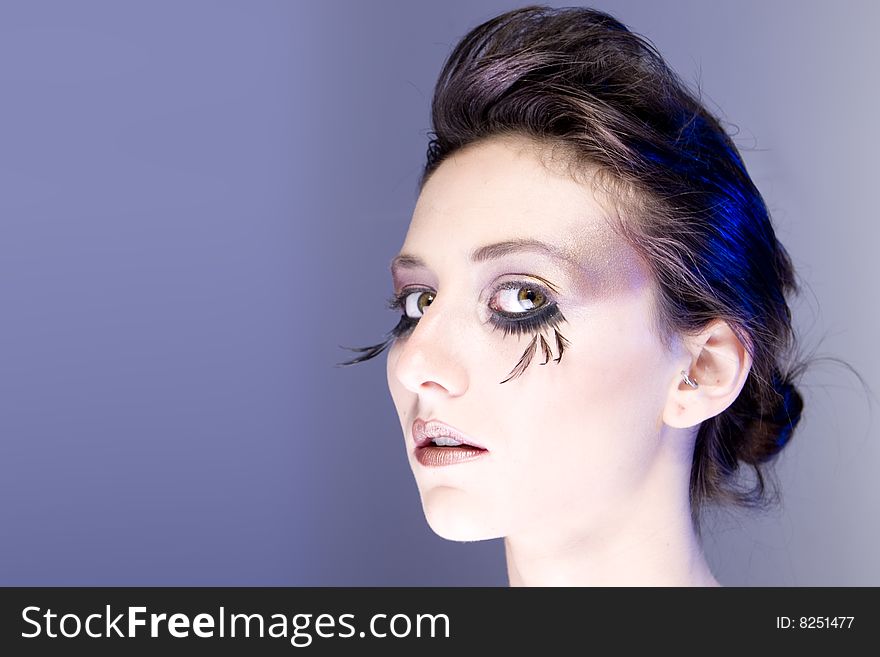 Attractive young lady with extravegant makeup and eyelashes closeup of head