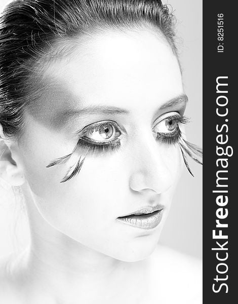 Attractive young lady with extravegant makeup and eyelashes in black and white