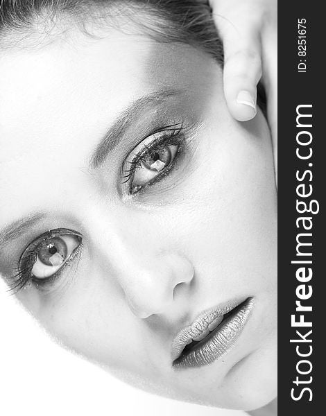Attractive young lady with extravegant makeup and black eyelashes black and white background with some gray