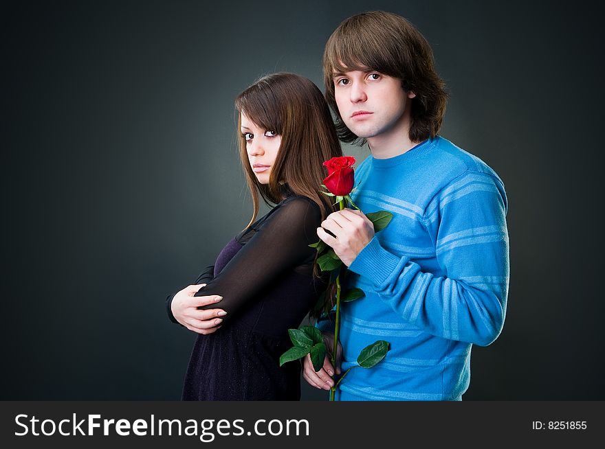 Young lovely couple with rose, studio shot