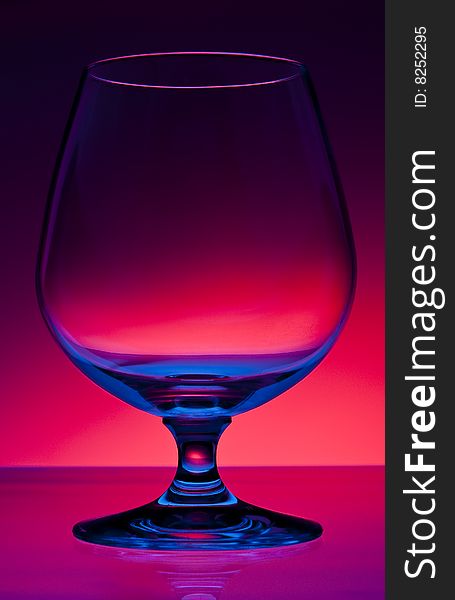 Empty hard drink glass on dark red gradient background. Empty hard drink glass on dark red gradient background