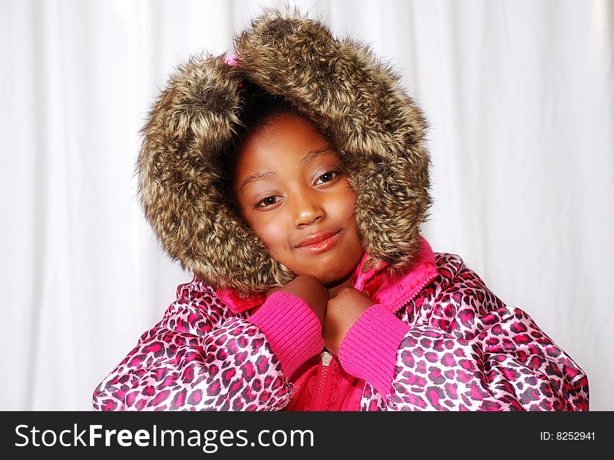 Girl posing in a winter coat with furry hood.