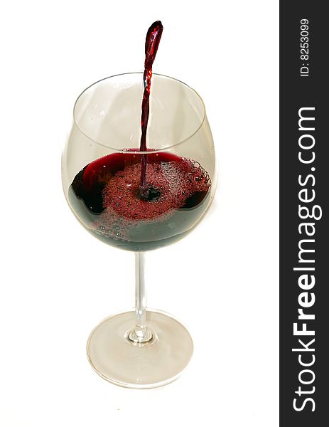 Pouring red wine into wineglass isolated on white