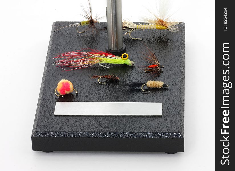 Assorted flies for fly fishing on fly tying base. Assorted flies for fly fishing on fly tying base