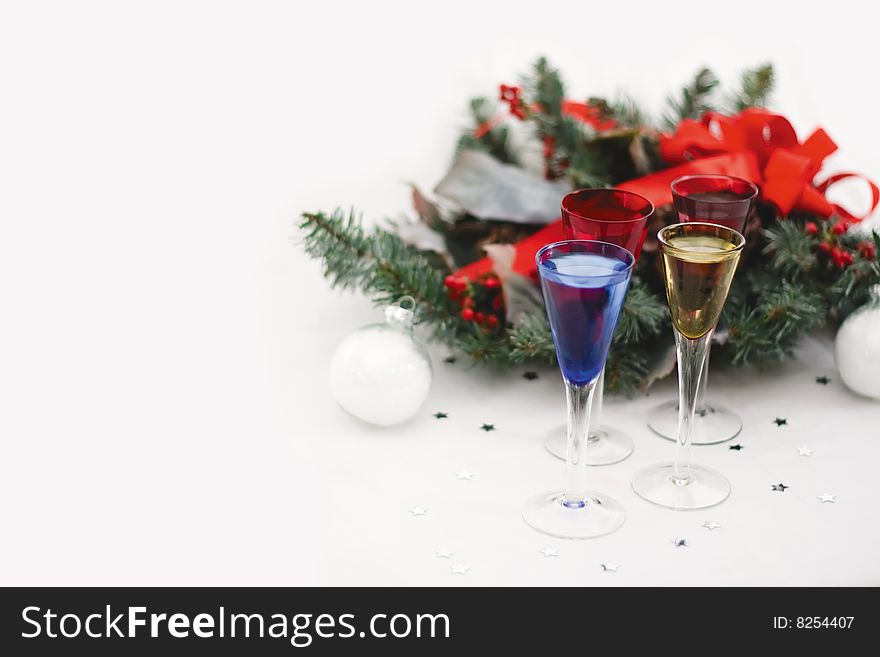 Four Festive Shot Glasses, Christmas bow, Wreath, and two white ornaments. whitespace for text. Four Festive Shot Glasses, Christmas bow, Wreath, and two white ornaments. whitespace for text