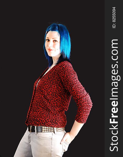 Lovely girl in a red top, jeans and bright blue hair looking smiling in the camera, on black background. Lovely girl in a red top, jeans and bright blue hair looking smiling in the camera, on black background.