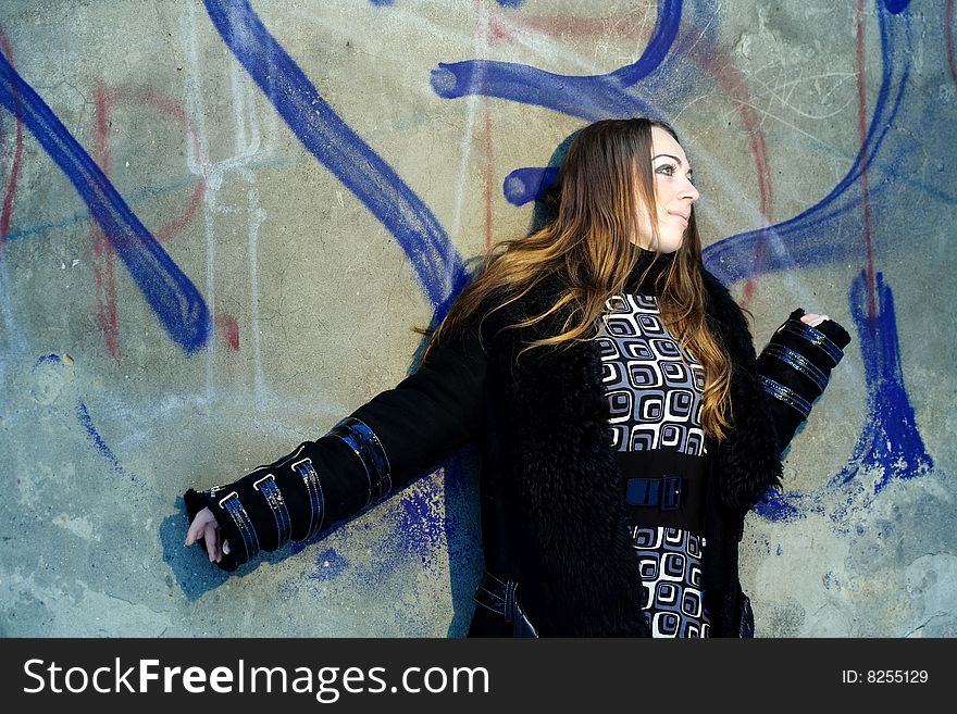Stock photo: an image of a nice girl standing at the wall