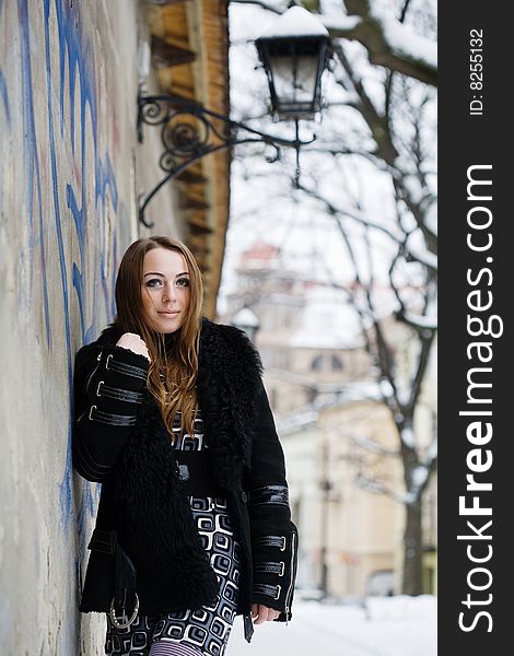 Stock photo: an image of a beautiful girl standing at the wall. Stock photo: an image of a beautiful girl standing at the wall