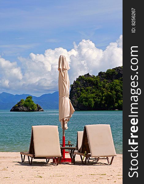 Sun loungers and parasol on a tropical beach in Malaysia. Sun loungers and parasol on a tropical beach in Malaysia