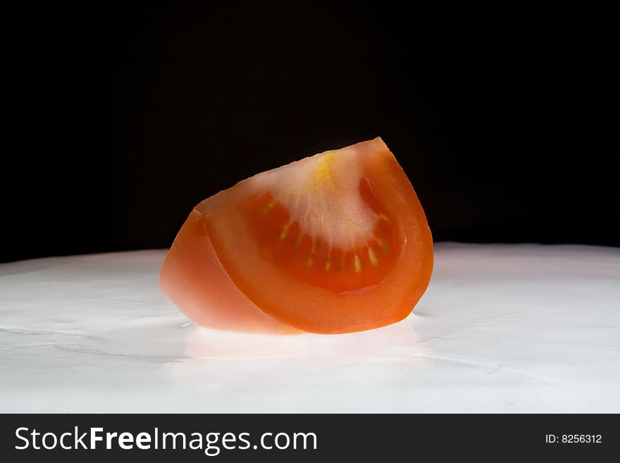 Red tomato on white ice. Studio shouting.