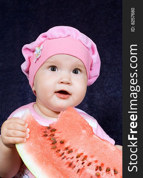 Child sits with red watermelon with pleasure his(its) eats. Child sits with red watermelon with pleasure his(its) eats