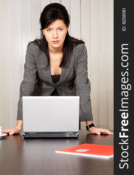 Young pensive caucasian businesswoman with laptop in the office