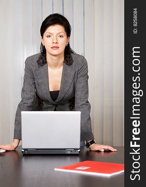 Young pensive caucasian businesswoman with laptop in the office