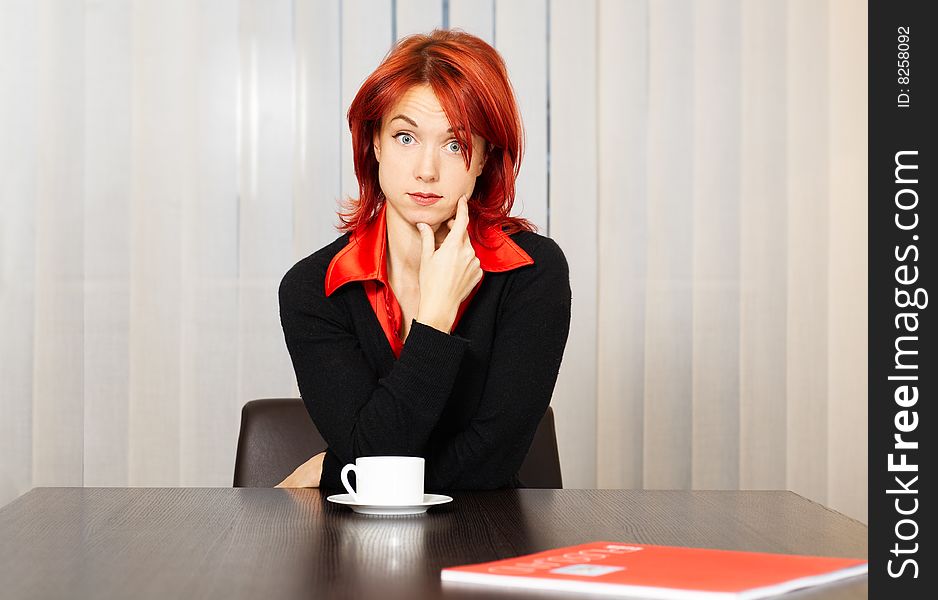 Young pensive caucasian businesswoman in the office