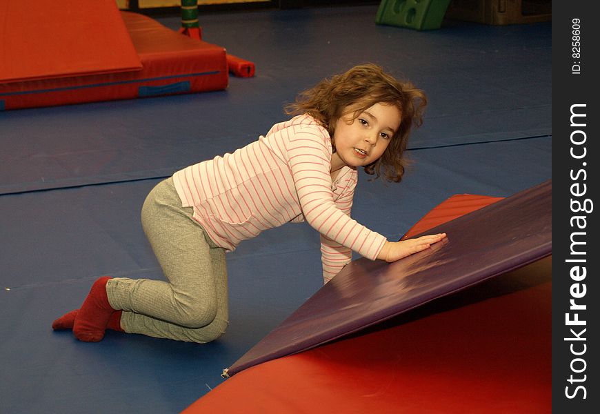 Young girl playing at an indoor playground having a good time. Young girl playing at an indoor playground having a good time.