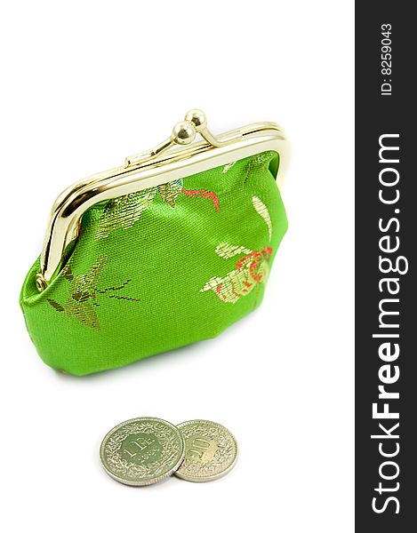 Green purse with some coins in front of it. Green purse with some coins in front of it