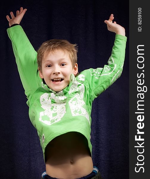 Boy jumps having extended both hands on turn blue background. Boy jumps having extended both hands on turn blue background