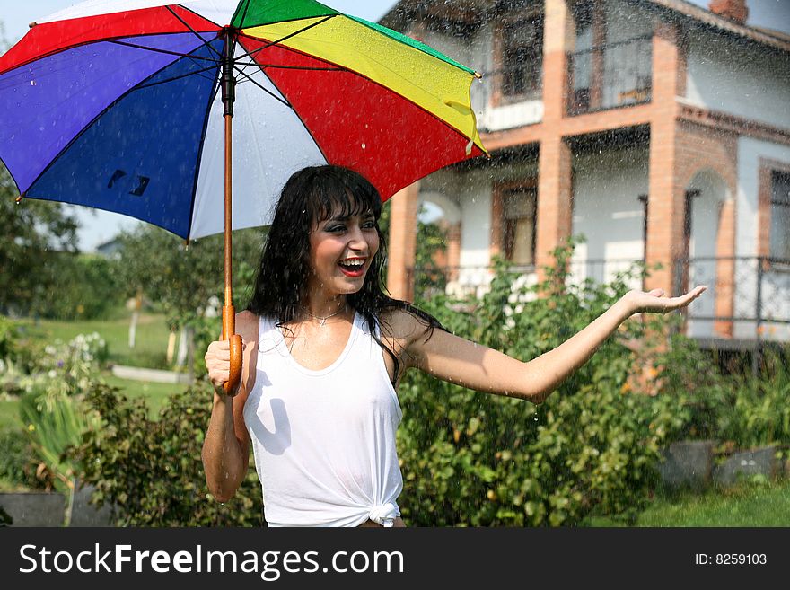 Girl under umbrella in summer rain